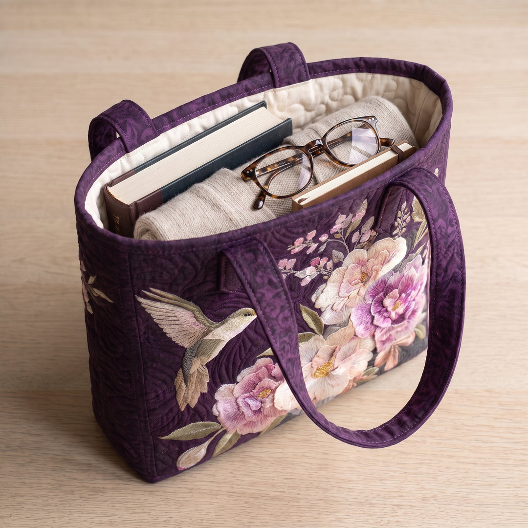 Artisanal Quilted Bag - Hummingbirds and Orchids — packed with a hardback book, a folded cardigan and reading glasses